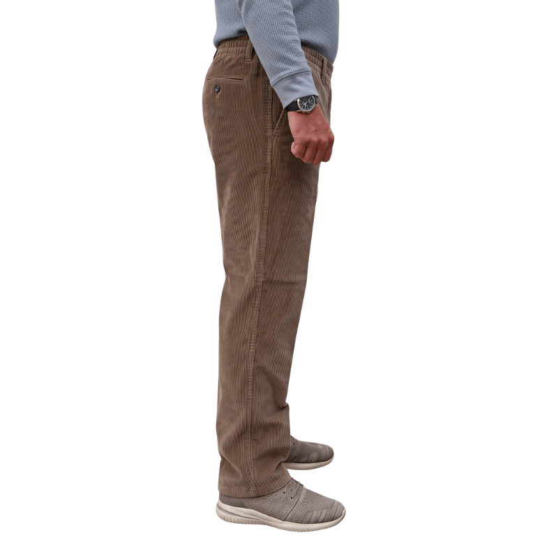 Zijprofiel van een bruine corduroy broek met elastische tailleband en voorzak, gedragen door een persoon
