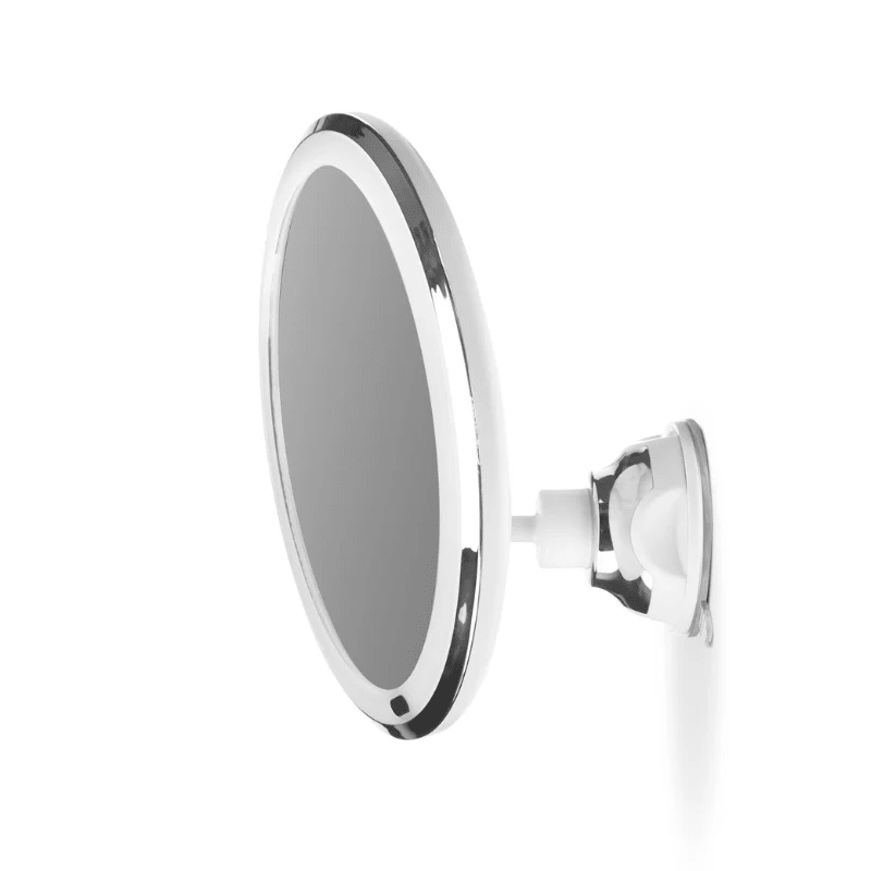 Miroir de maquillage avec lumière et ventouse vu de côté, monté sur une surface blanche lisse