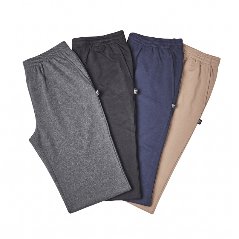 Quatre pantalons de jogging gris, noirs, bleus et beiges, vus de dessus avec taille élastique et poches latérales