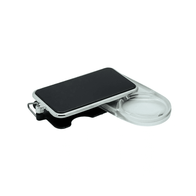 Loupe de poche noire avec grossissement 3,5x, vue de côté, partiellement ouverte avec la lentille claire visible